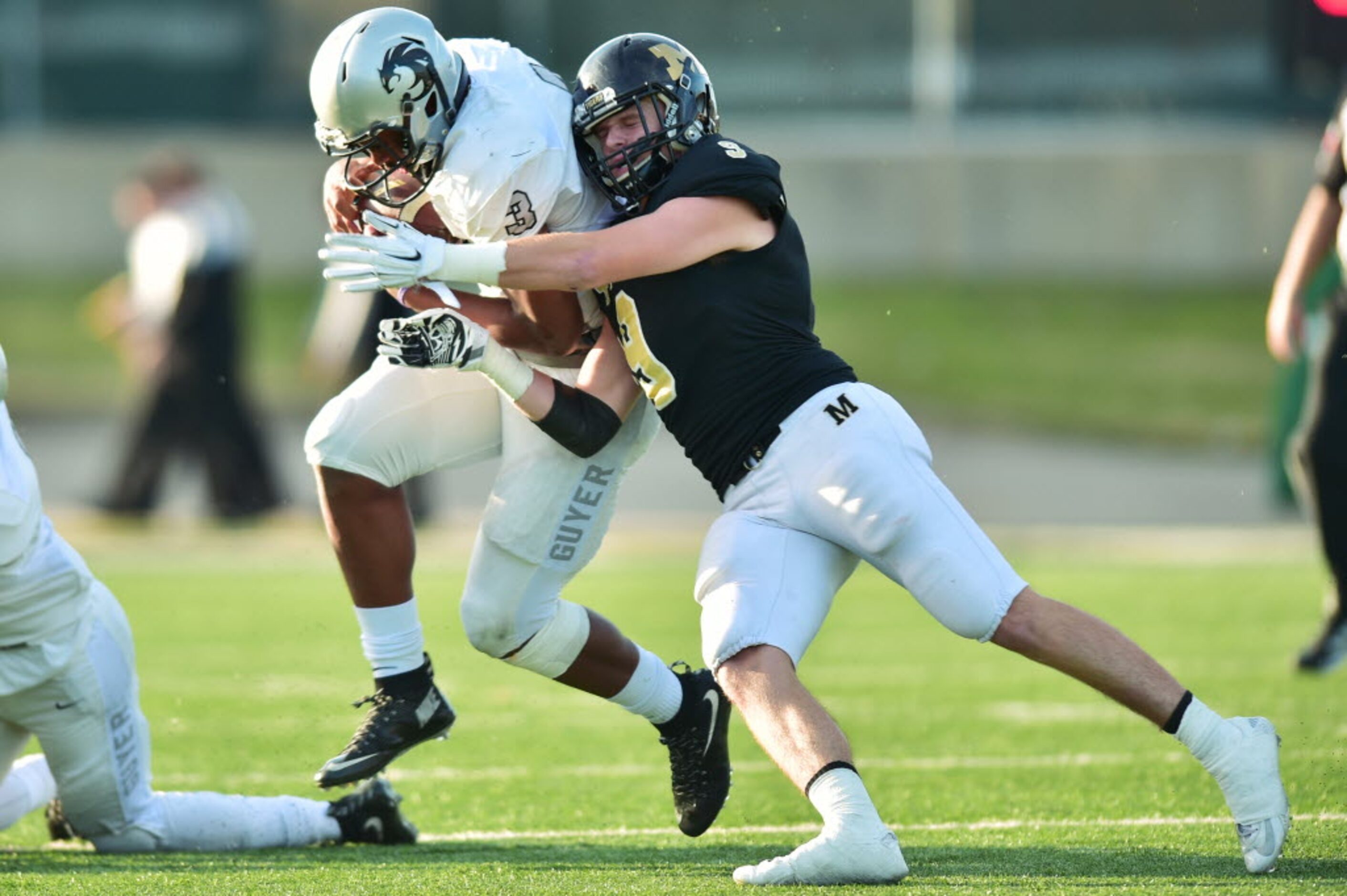 Guyer junior quarterback Shawn Robinson (3) is grabbed by Mansfield senior safety Sean...