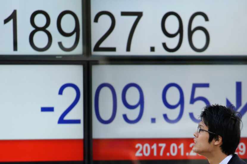 A man looks at an electronic stock board of a securities firm in Tokyo, Monday, Jan. 23,...