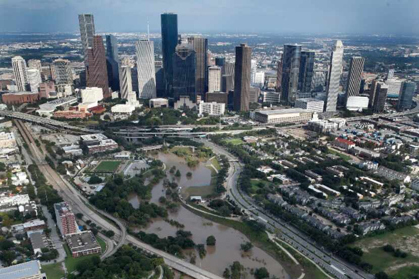 The swollen Buffalo Bayou is seen with the Houston skyline as a backdrop on Aug. 30, 2017....