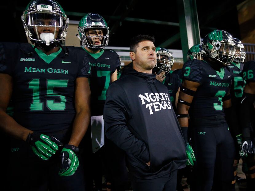 North Texas Mean Green head coach Seth Littrell and his players wait to be introduced before...