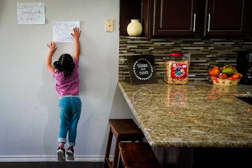 Kamila Cabrera, 4, jumped to touch a sign in the kitchen of her family’s Grand Prairie home...