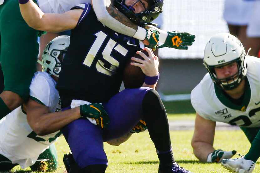 TCU Horned Frogs quarterback Max Duggan (15) is brought down by a swarm of Baylor Bears...