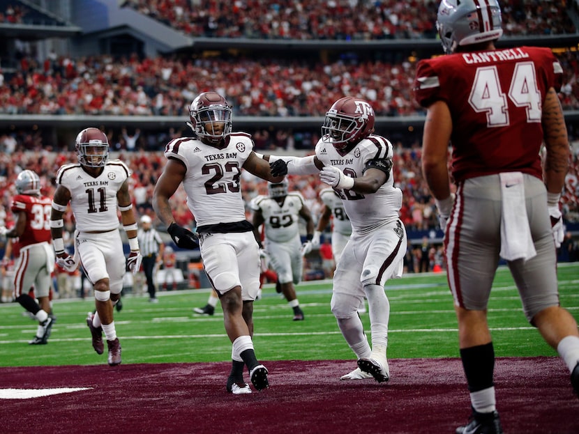 Texas A&M Aggies defensive back Armani Watts (23) is congratulated by linebacker Otaro Alaka...