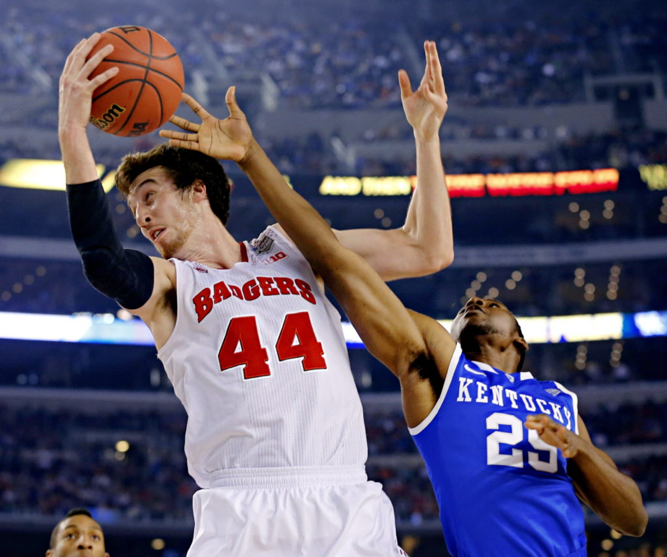 Wisconsin Badgers forward Frank Kaminsky (44) pulls a rebound under pressure from Kentucky...