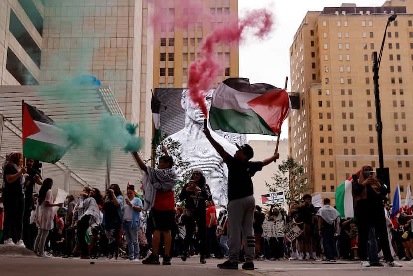 Some demonstrators set off red and green smoke in honor of Palestine.