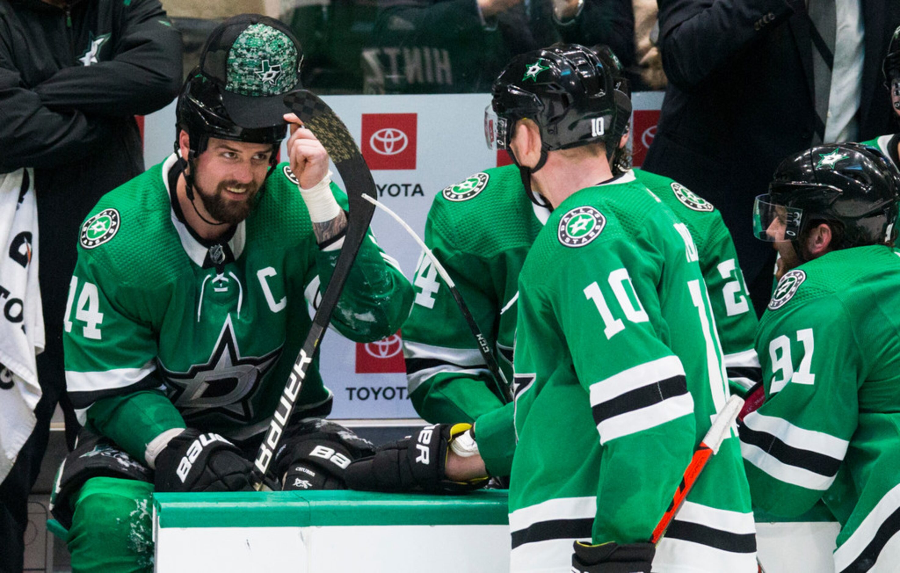 Dallas Stars left wing Jamie Benn (14) puts on a hat thrown on the ice by a fan after he...