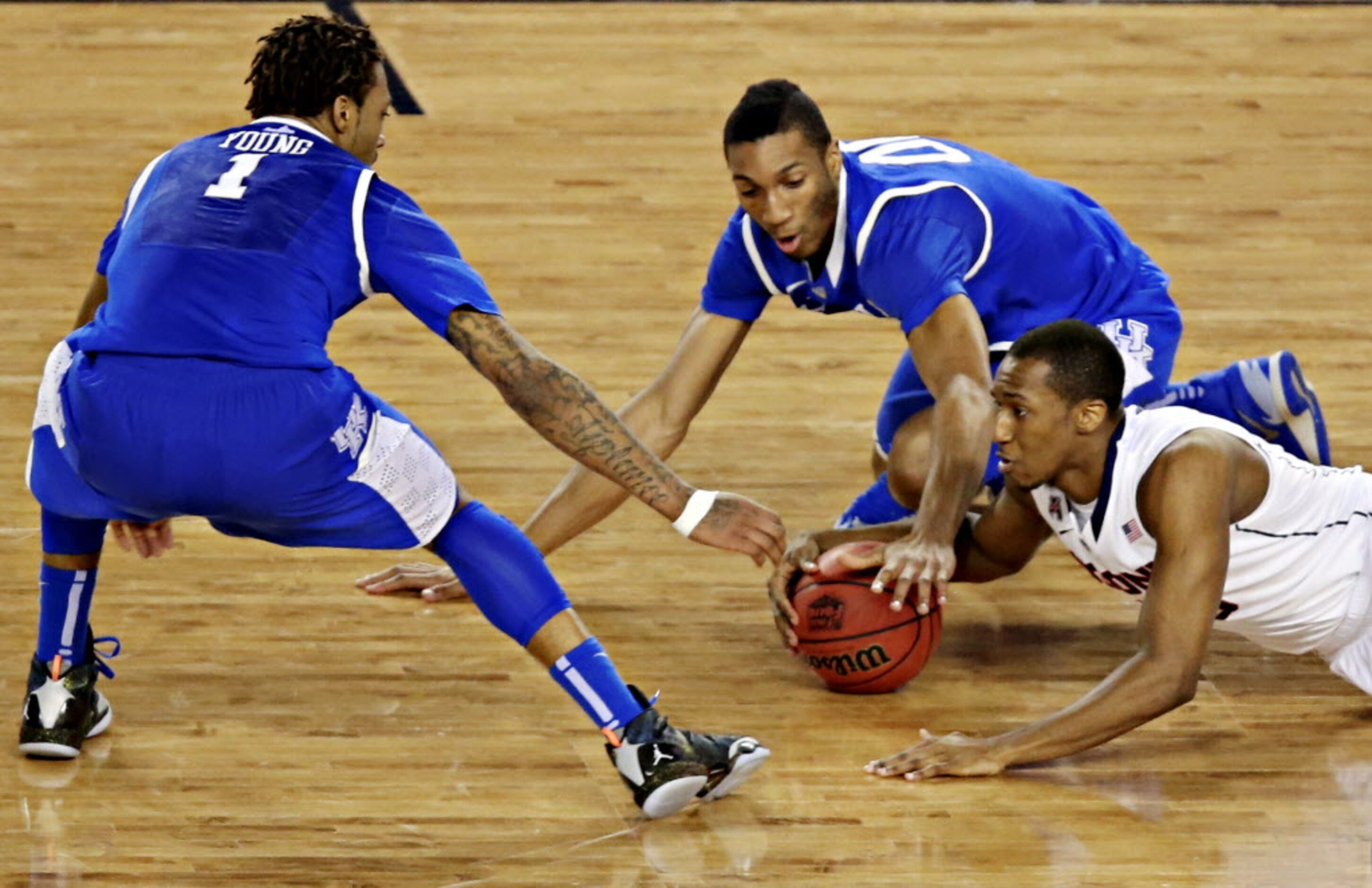 Kentucky Wildcats guard/forward James Young (1) and forward Marcus Lee battle Connecticut...