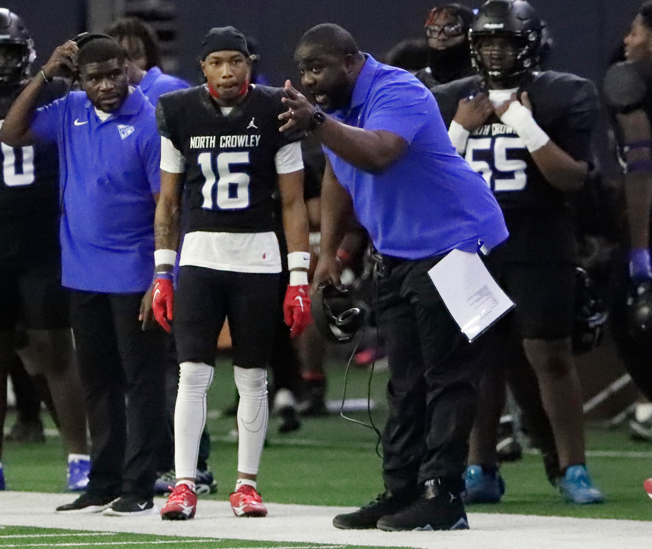 North Crowley High School head coach Ray Gates talks to North Crowley High School defensive...