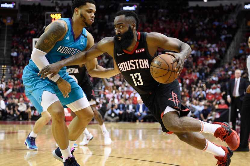 Houston Rockets guard James Harden (13) dribbles around Charlotte Hornets forward Miles...