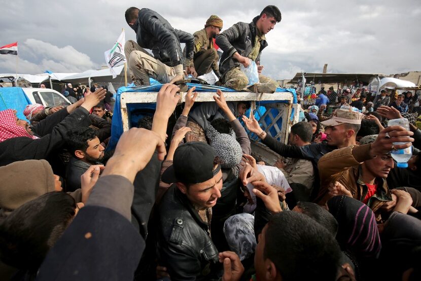 Iraqis, displaced from Mosul, receive aid rations at the Hammam al-Alil camp for the...