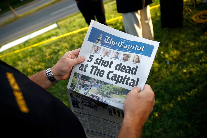 Steve Schuh, county executive of Anne Arundel County, holds a copy of The Capital Gazette...