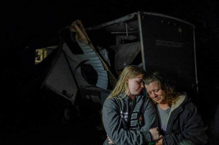 Brittaney Deaton, 17 (left), comforts her mother Amber Zeleny, 53, while speaking with...