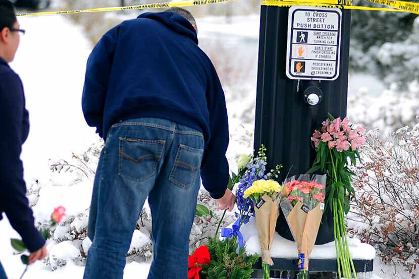 Colorado Springs, Colo., residents Paul Nice and Denise Anchondo lay flowers Saturday in...