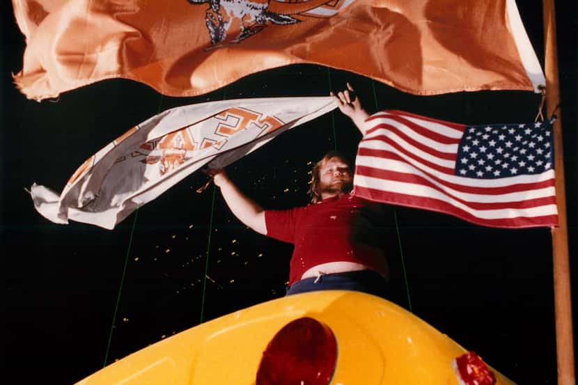 Johnny Wallace, of Dallas, stands on top of a bus on Commerce Street shouting to Oklahoma...