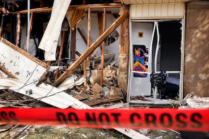 The bottom floor of an apartment explosion and fire is seen behind fire line tape in the...