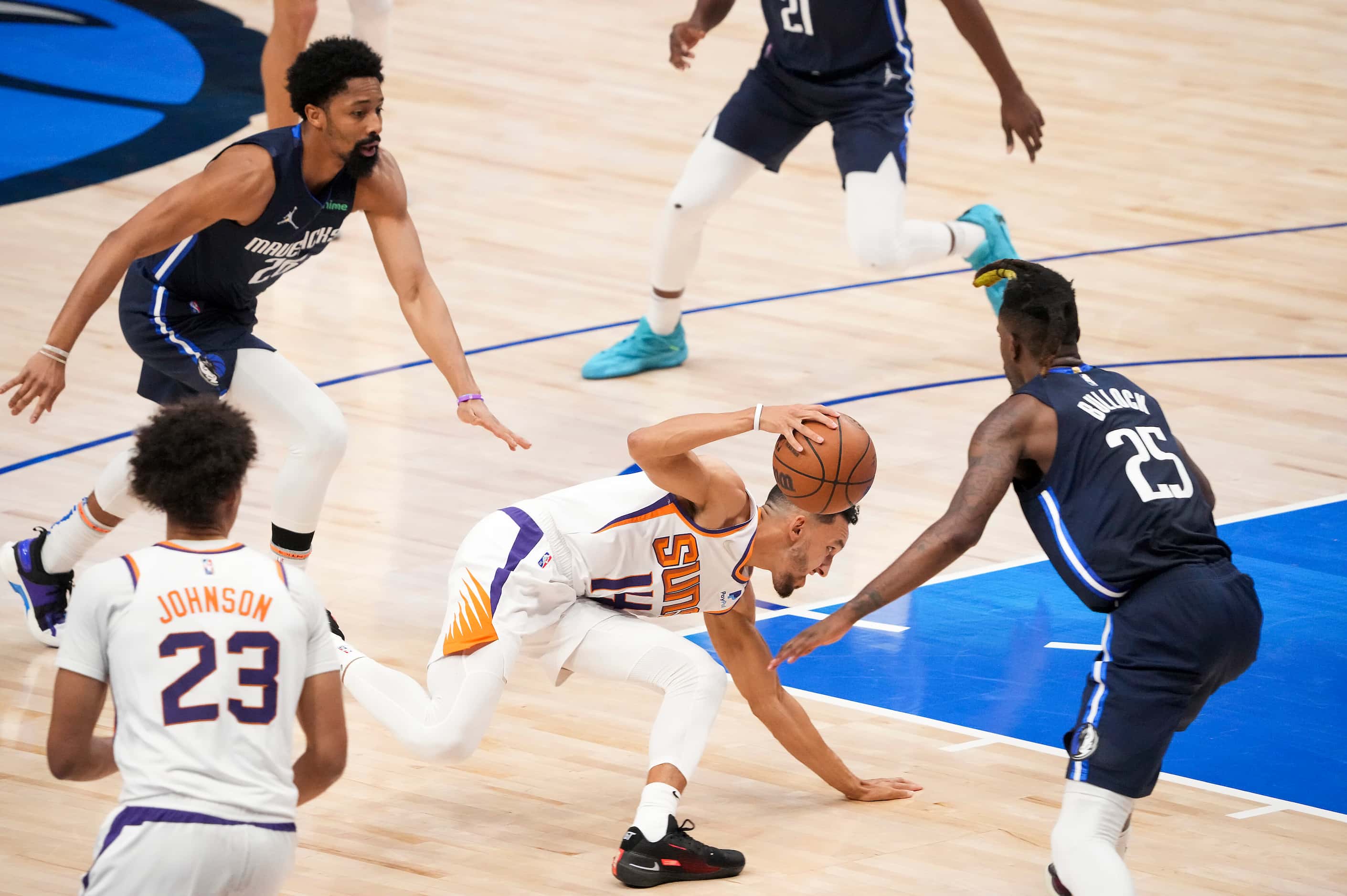 Phoenix Suns guard Landry Shamet (14) slips to the floor as he tries to drive between Dallas...