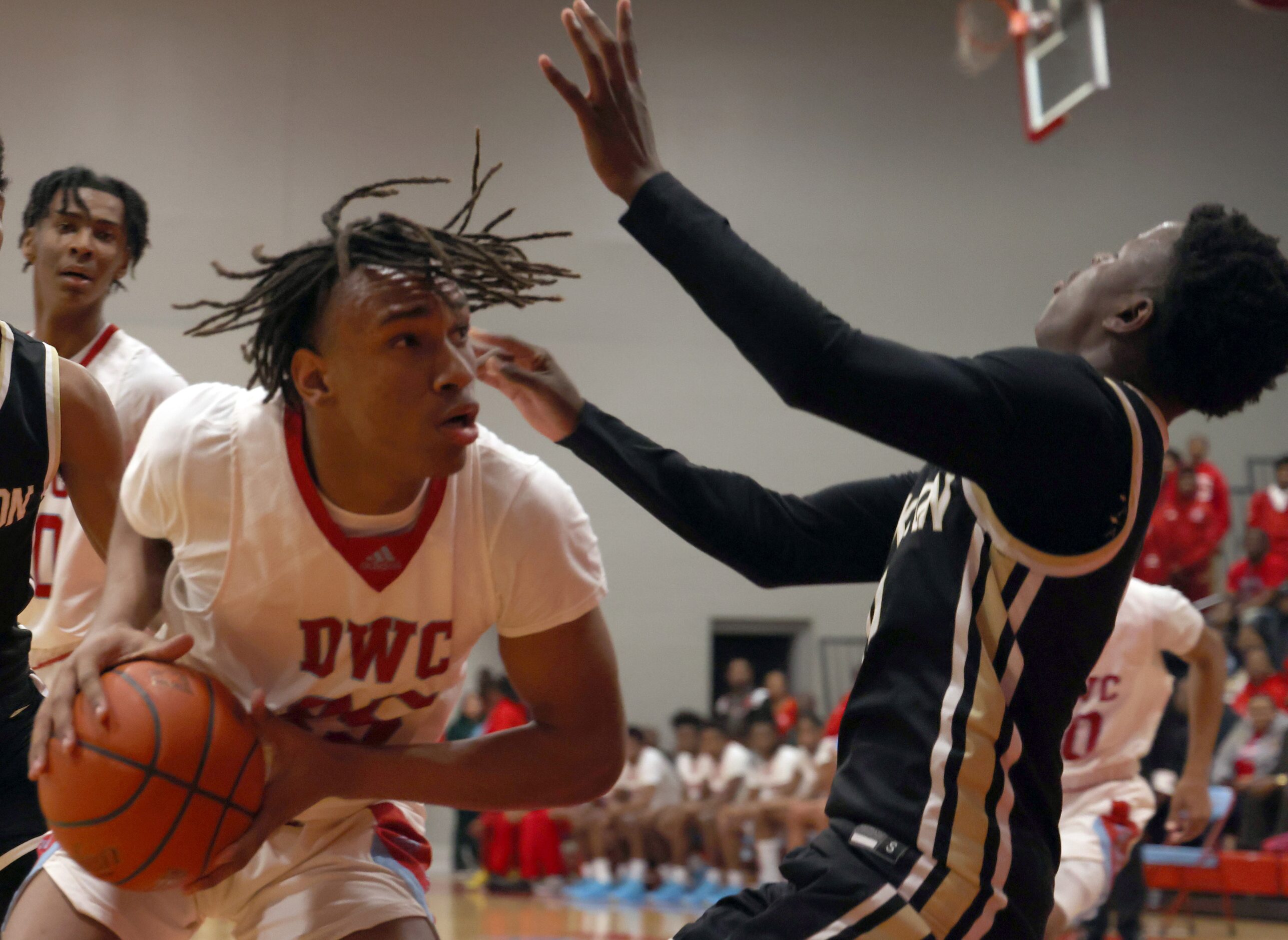 Dallas Carter guard Kole Williams (25) drives to the basket and collides with Dallas...