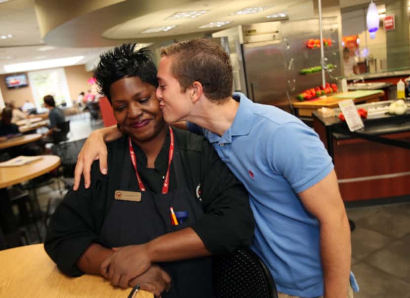 Cafeteria employee Tamerlyn Holmes, 37, also known as Momma T, receives a kiss from her new...