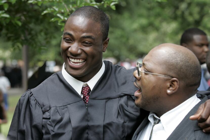 DeMarcus Ware shares a laugh with his father Otis Pitts after graduation at Troy State...