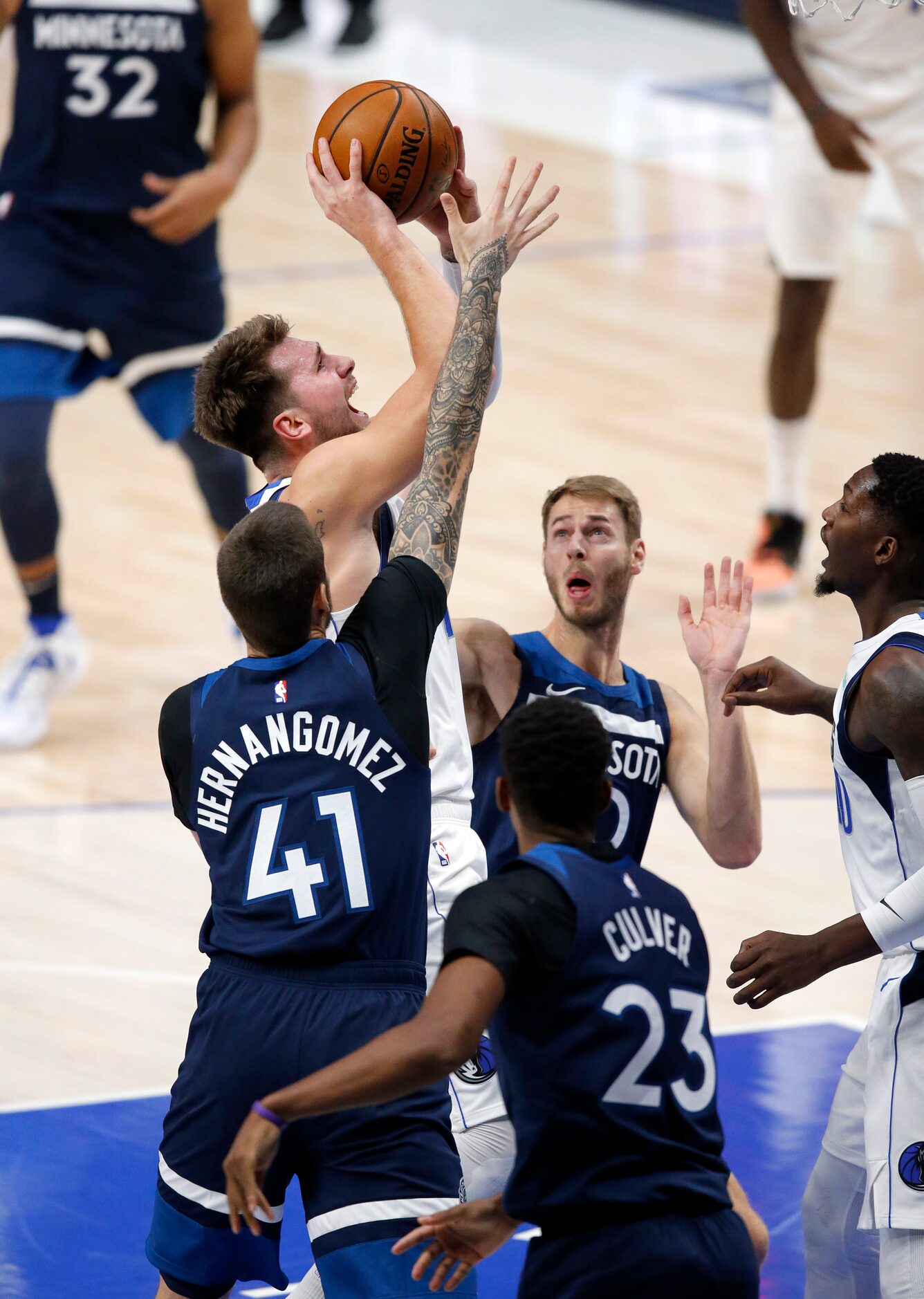 Dallas Mavericks guard Luka Doncic (77) drives into the lane and takes a shot over Minnesota...