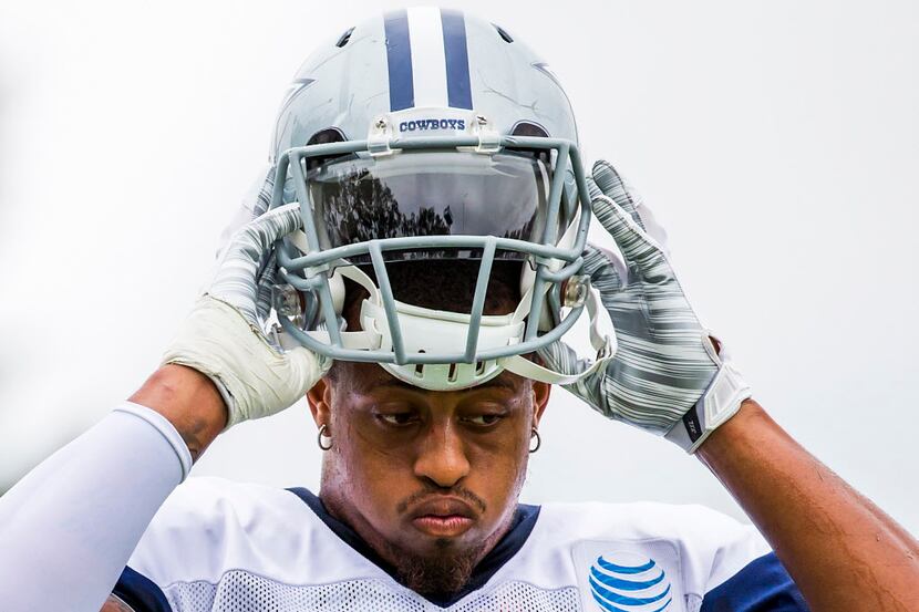 Dallas Cowboys defensive end Greg Hardy pulls on his helmet during a joint practice with the...