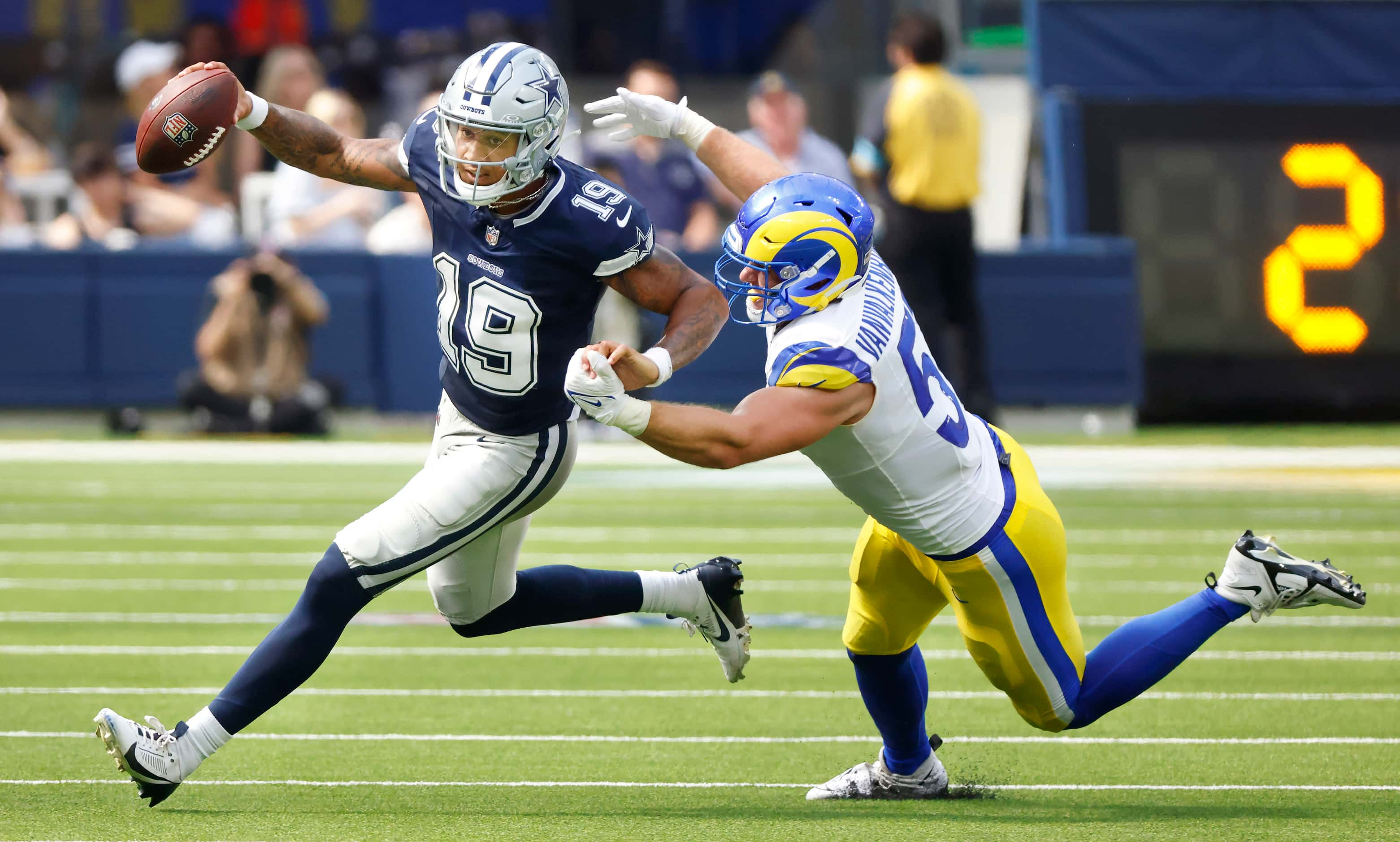 Dallas Cowboys quarterback Trey Lance (19) tries to elude the grasp of Los Angeles Rams...