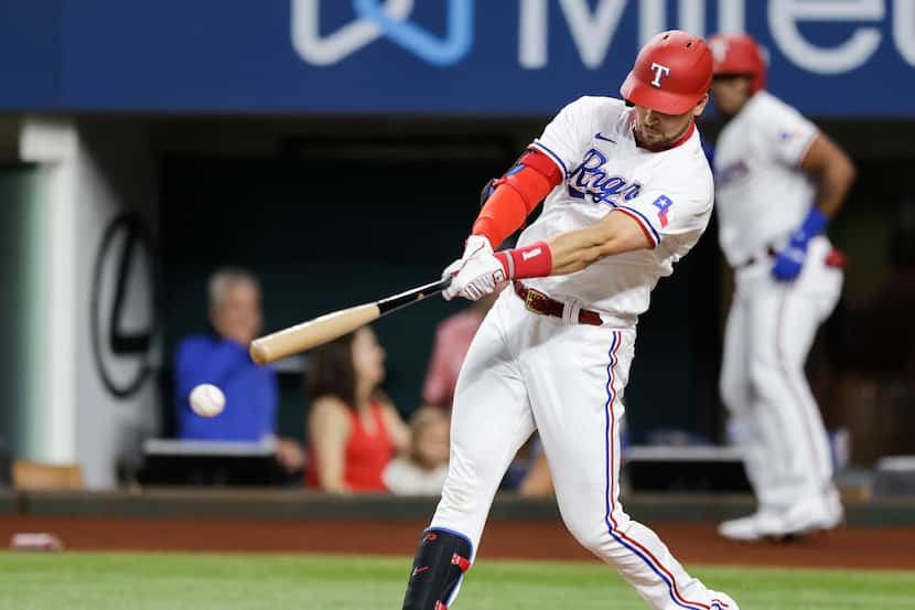 Texas Rangers’  Nate Lowe connects for an RBI double during the first inning of a baseball...