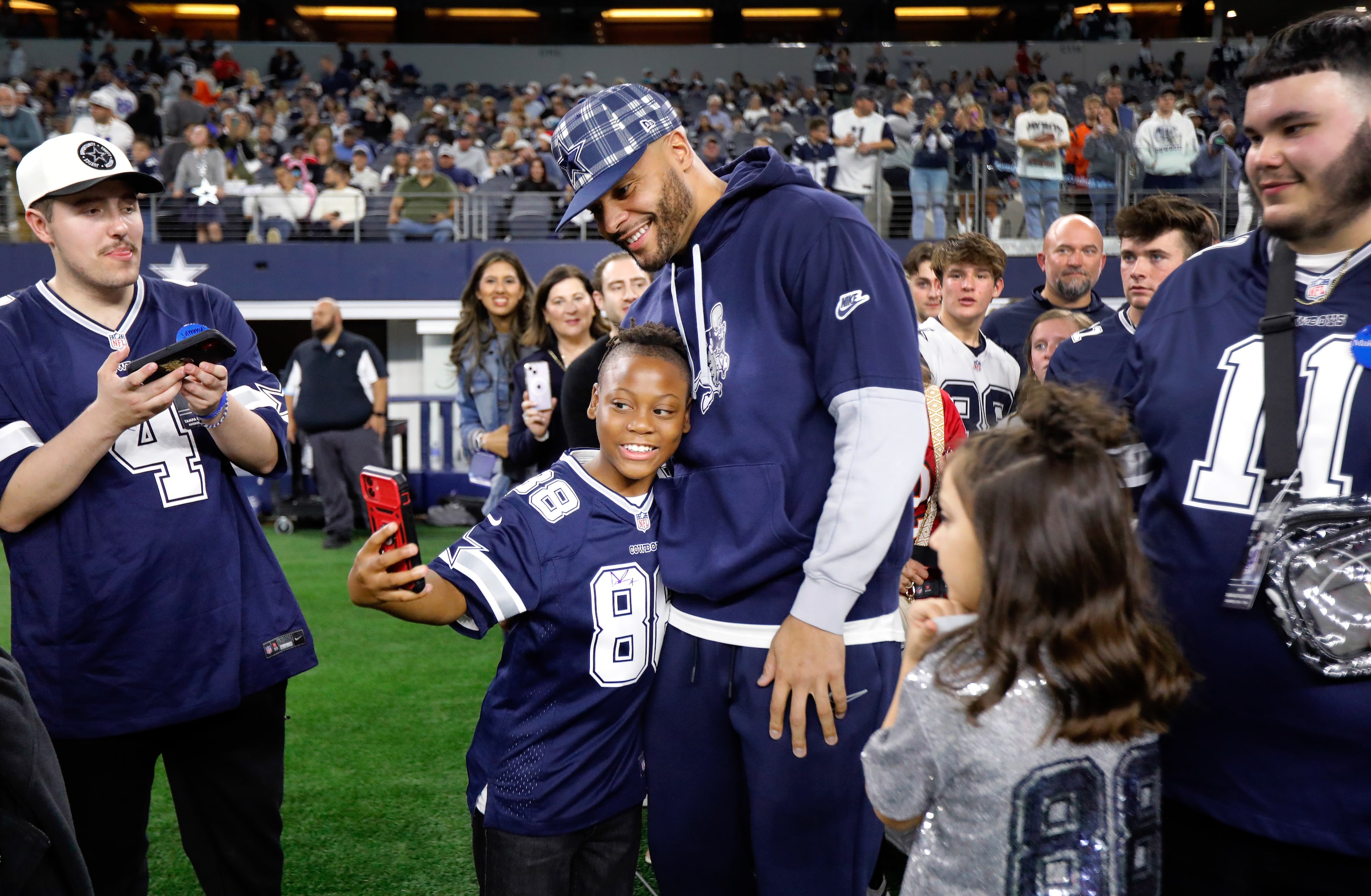 Injured Dallas Cowboys quarterback Dak Prescott takes photos with kids from the Make-A-Wish...