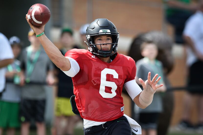 North Texas junior quarterback Mason Fine (6) throws a pass to a teammate, while being...