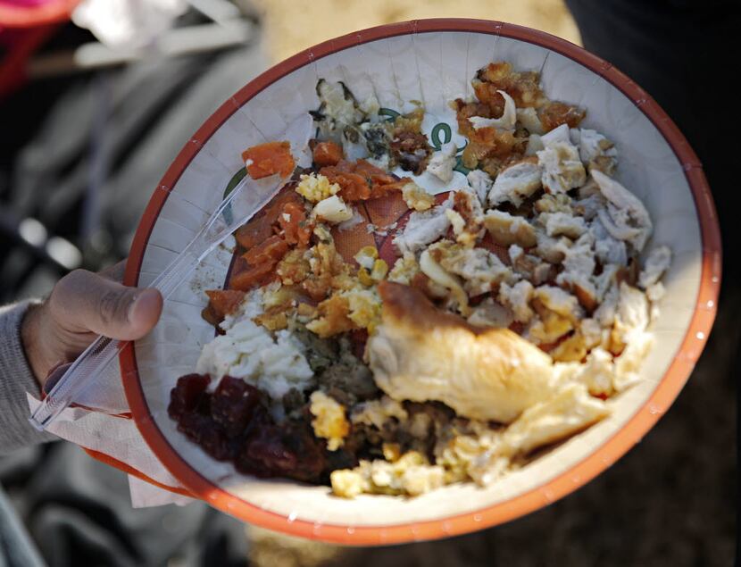 Kyle Thomas holds a plate of Thanksgiving food before the Dallas Cowboys game against the...