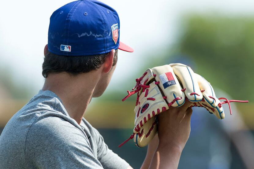 Texas Rangers' pitcher Owen White works on his delivery while doing a little long toss with...