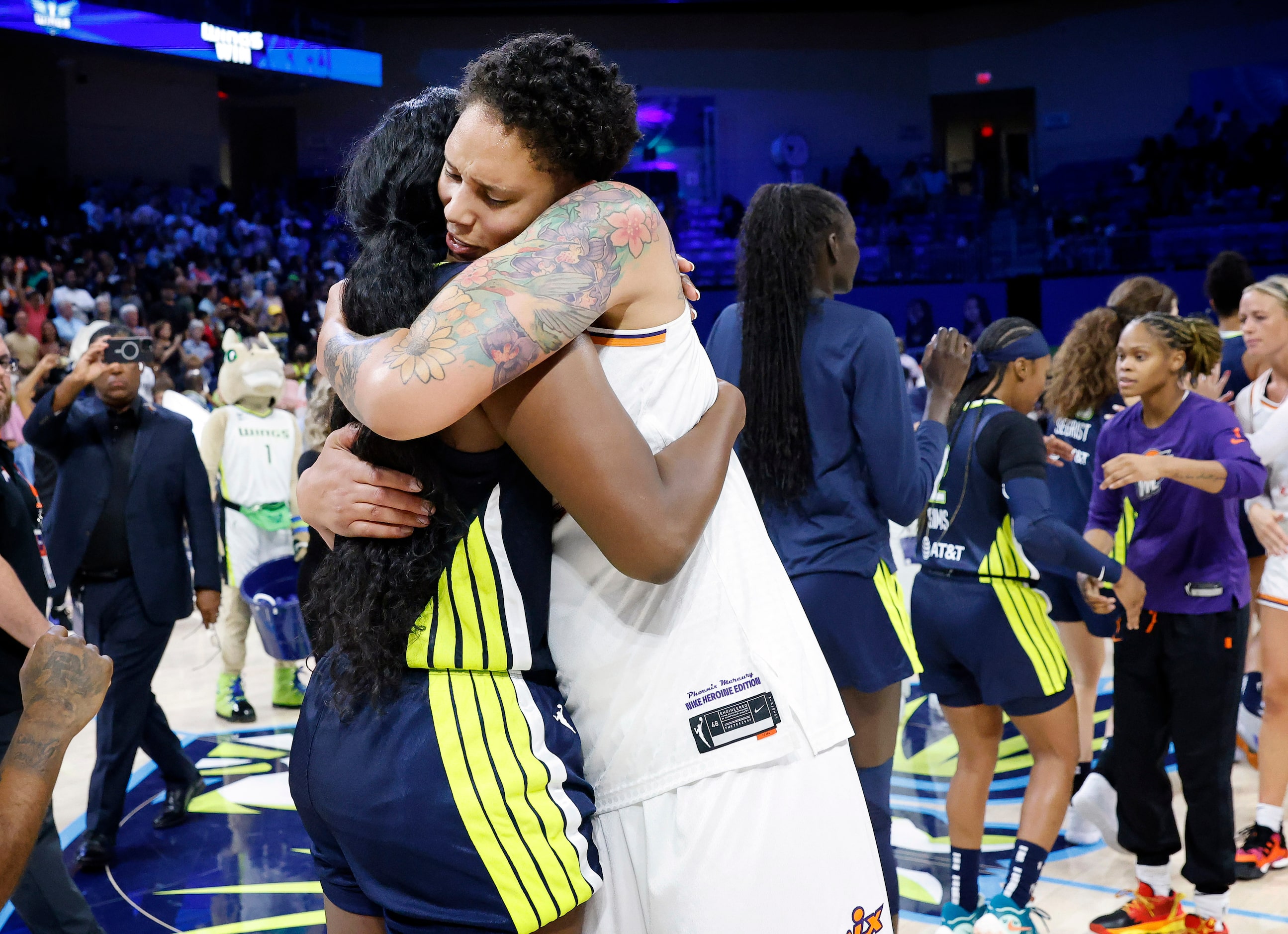 Dallas Wings center Kalani Brown (21) receives a congratulatory hug from Phoenix Mercury...