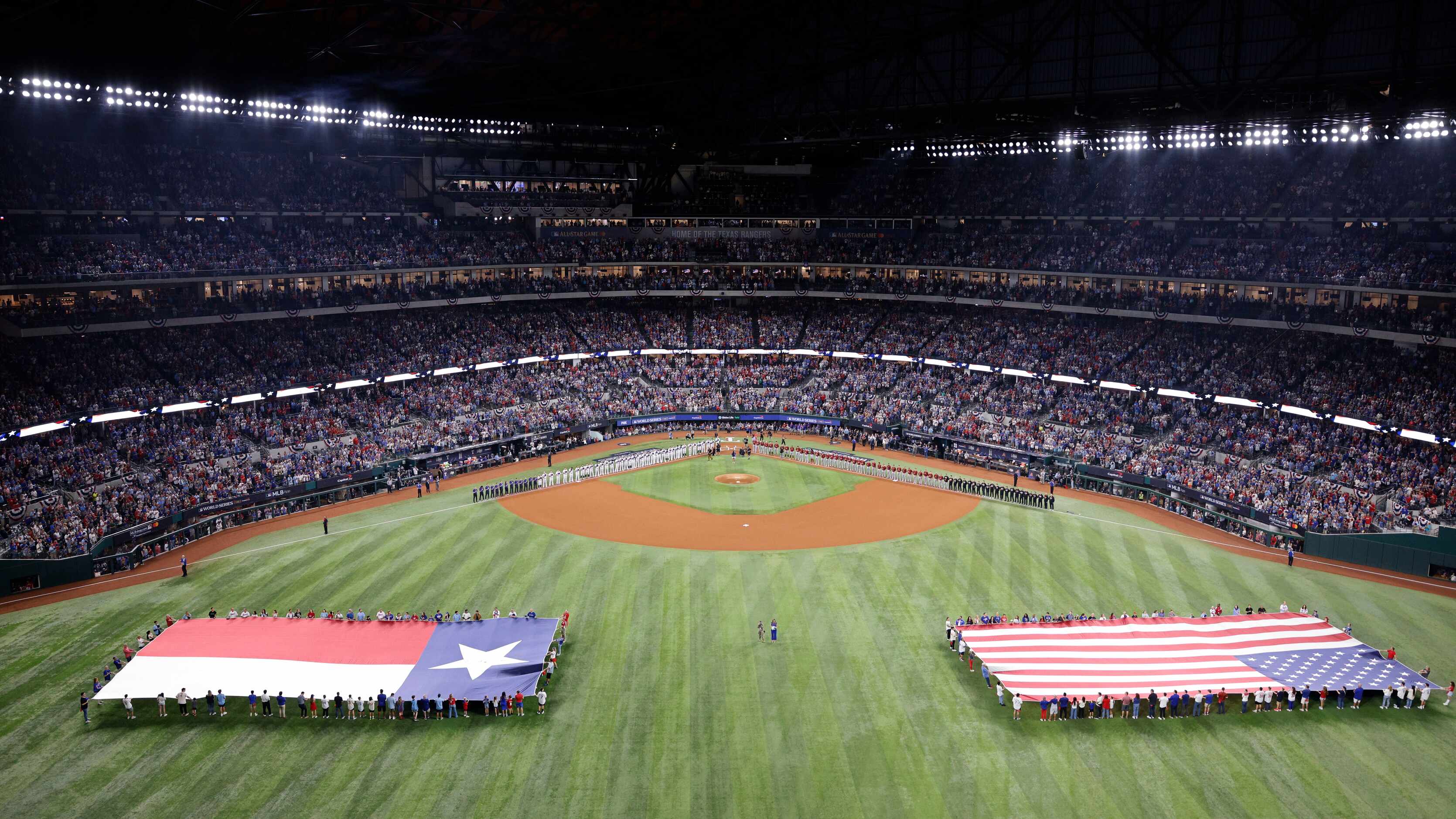 Players line up for the national anthem before Game 1 of the World Series between the Texas...