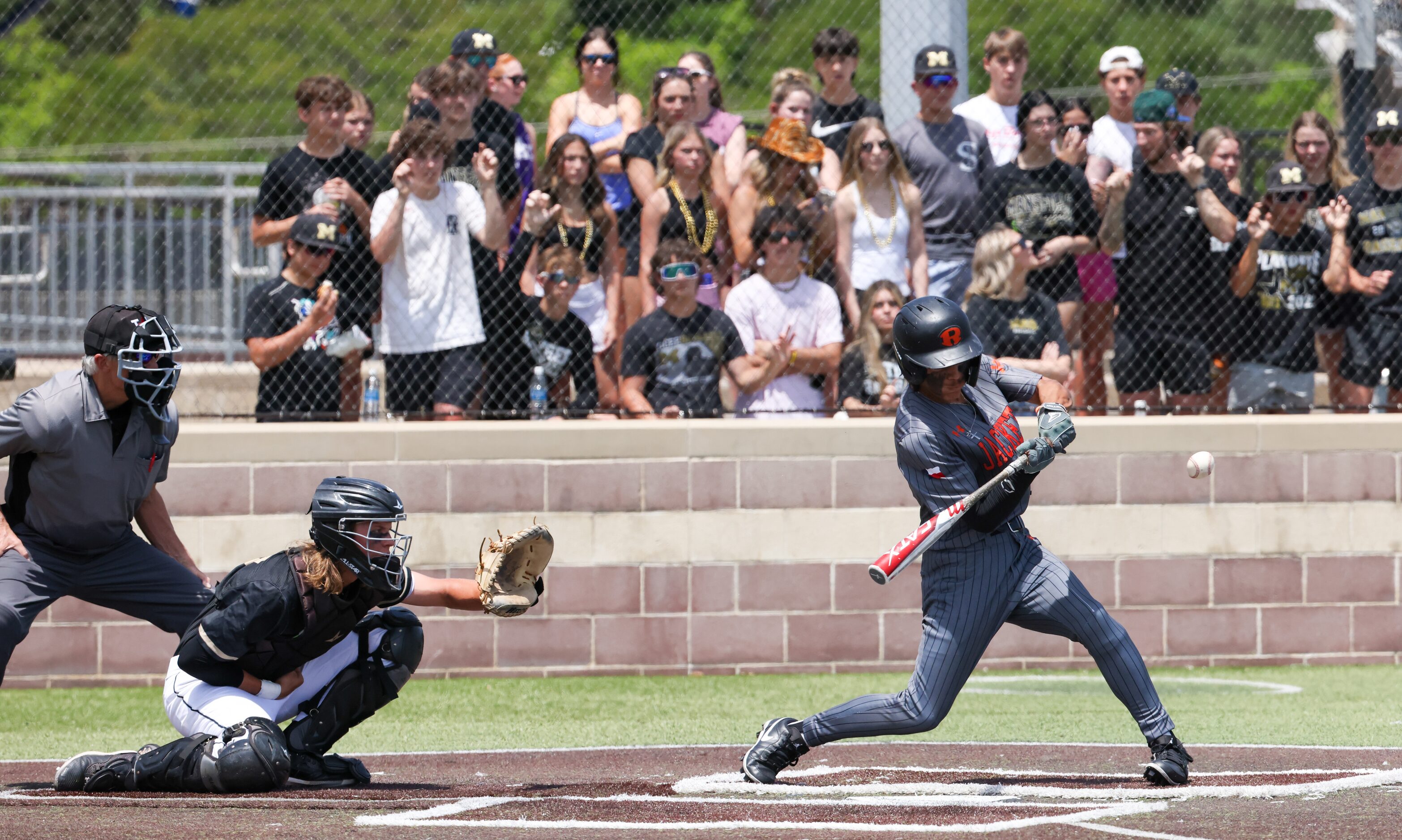 Rockwall senior outfielder Dylan Garcia (right) swings for a pitch during an early inning of...