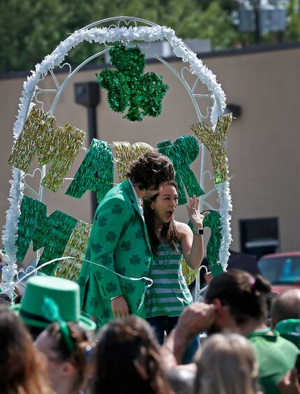 Bianca Caram (right) shows the crowd a ring after Mark Willey proposes to her on a float...