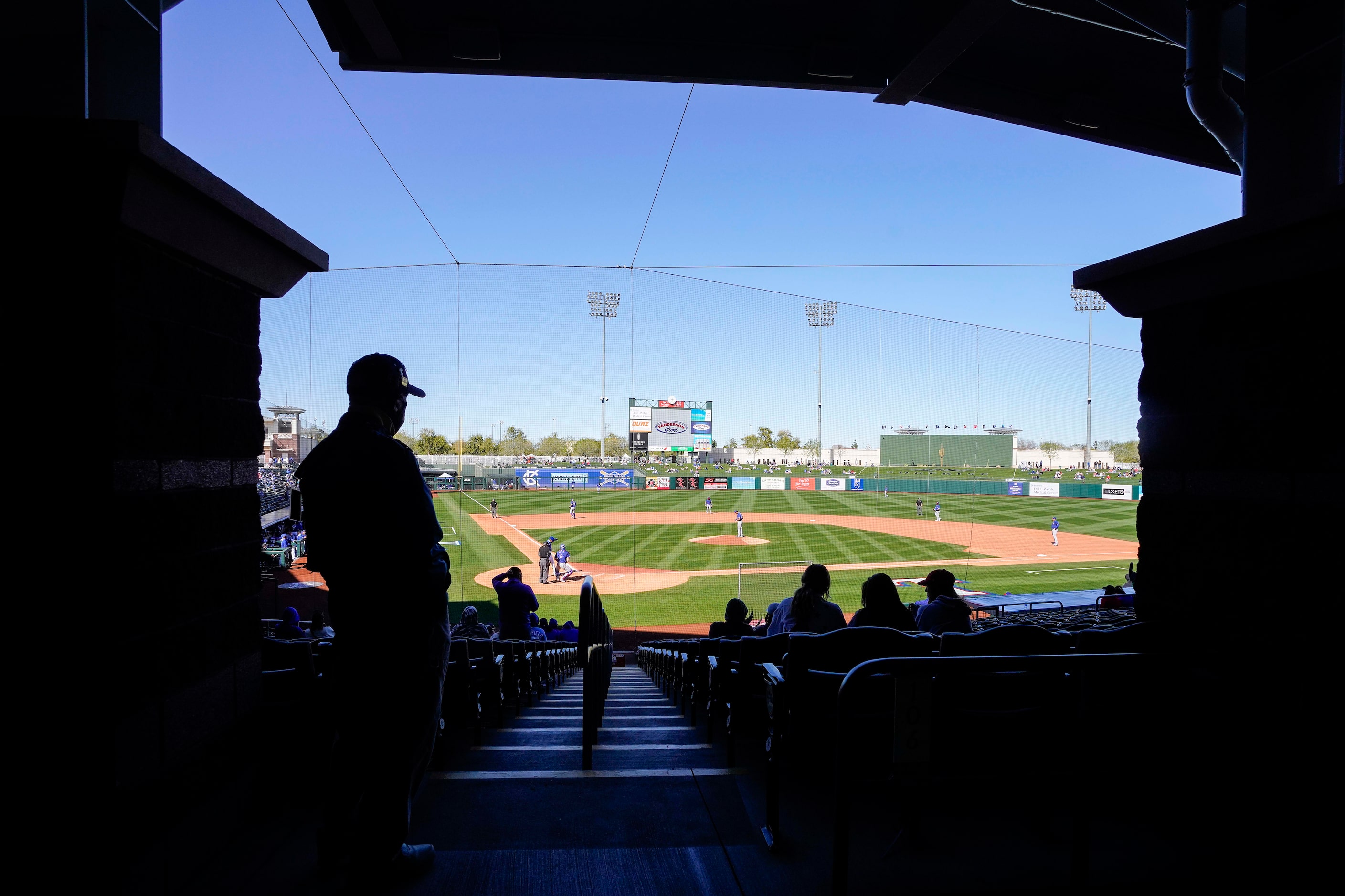 Fans watch from socially distant ‘pods’ during a spring training game between the Texas...