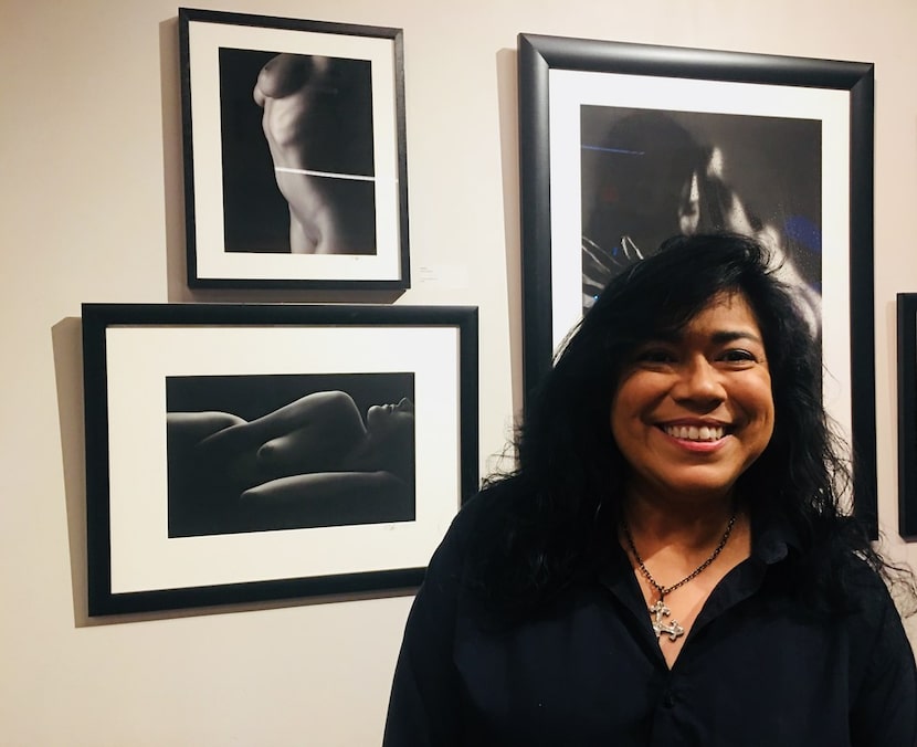 The photographer Debra Gloria poses with her photos during the art show MaricónX featuring...