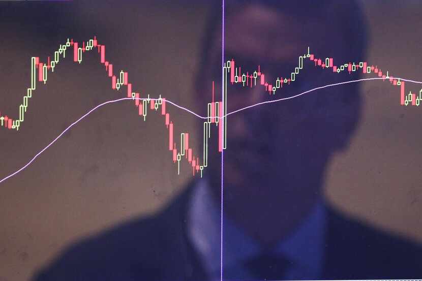 A trader was reflected  in a market screen on the floor of the New York Stock Exchange...