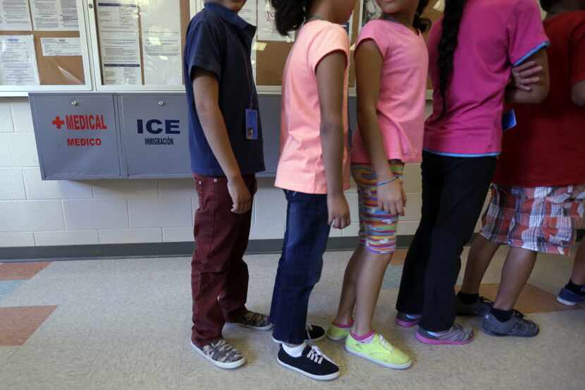 Immigrant children line up to eat in the cafeteria at the  Karnes County Residential Center,...
