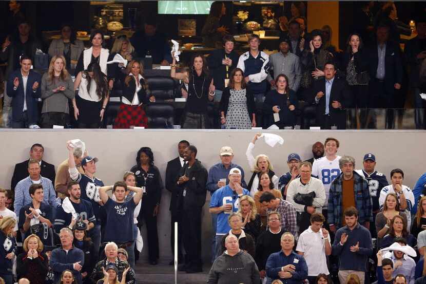 Fans cheer from the owners suite after the Dallas Cowboys scored against the Detroit Lions...