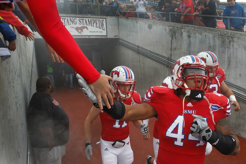 SMU LB Taylor Reed (44) slaps hands with fans as he takes the field before the SMU Mustangs...