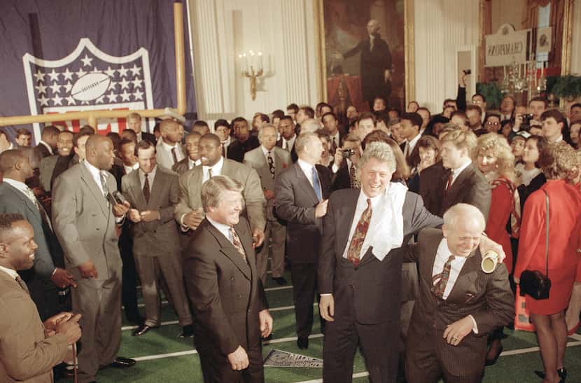 President Bill Clinton puts his arm around Larry Lacewell, Dallas Cowboys director of...