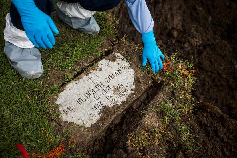 Calvary Hill Cemetery worker Andres Buenrostro removes the headstone of the Rev. Rudolph...