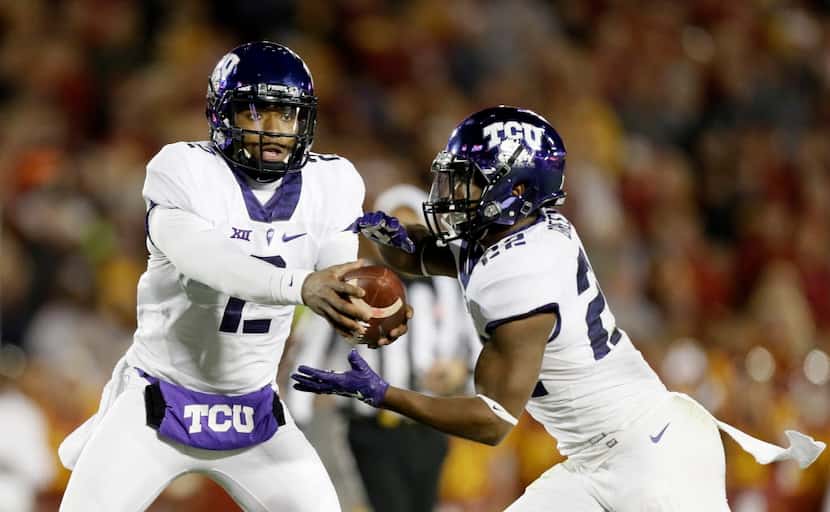 TCU quarterback Trevone Boykin hands the ball off to running back Aaron Green, right, during...
