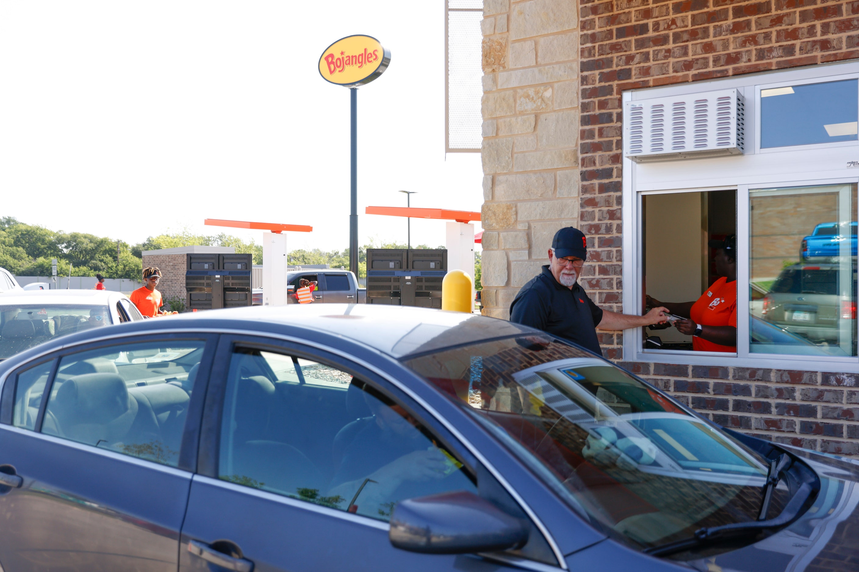 Visiting support Michael Carter takes a drive-through order during the opening day of...