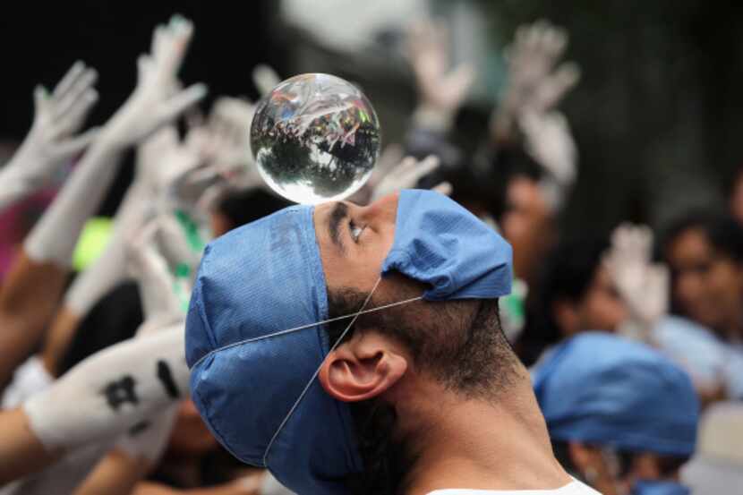 A student protester balances a crystal ball during a demonstration in front of Mexico's...