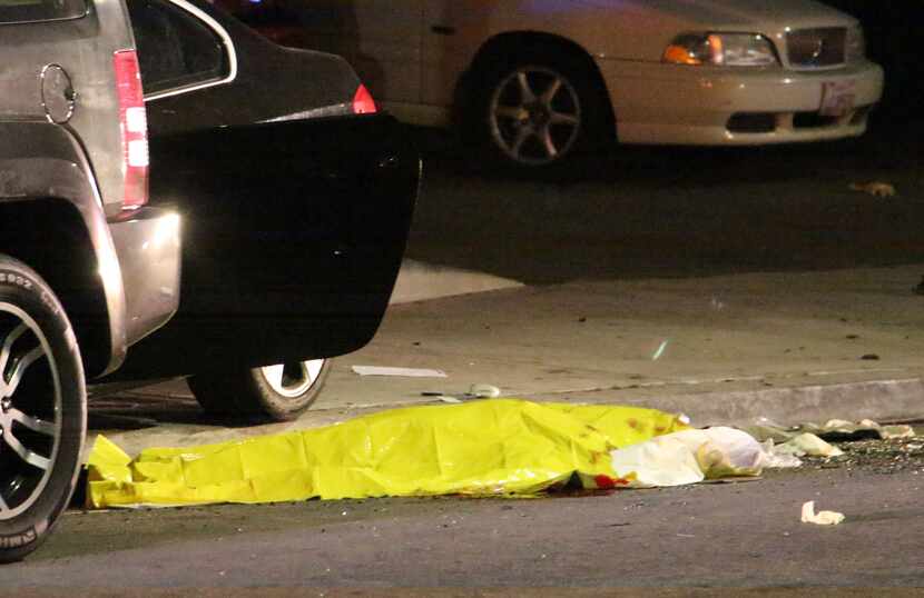In this image provided by KEYT-TV, a body is covered on the ground after a mass shooting...