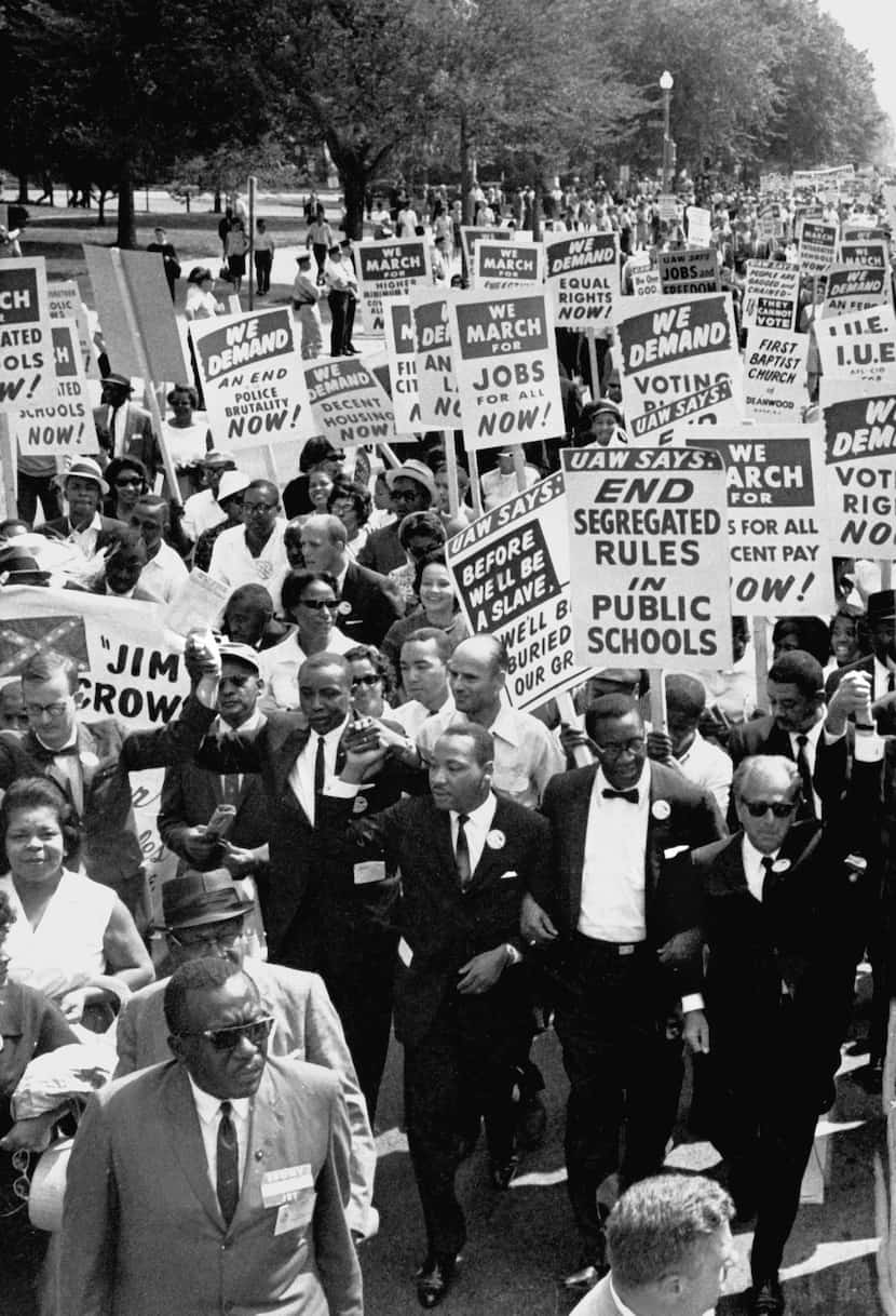 Dr. Martin Luther King Jr. (center front) led a sea of protesters during the March on...