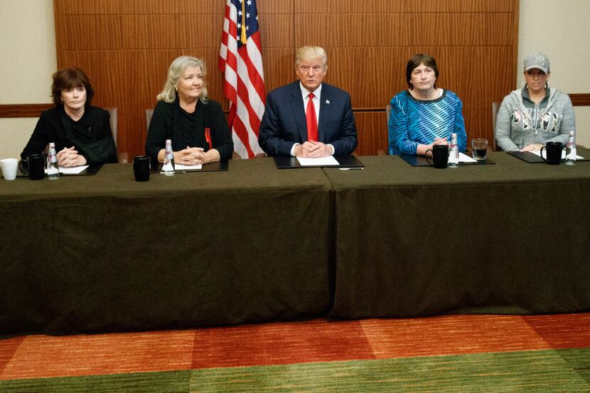 Republican presidential candidate Donald Trump, center, sits with, from right, Paula Jones,...