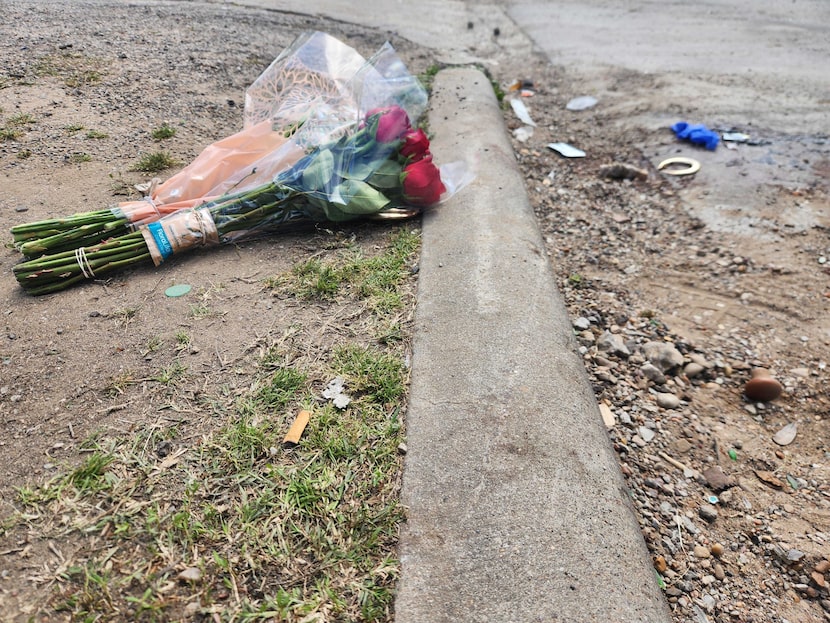 Two small bundles of flowers, along with a gold-colored earring and a blue latex glove lie...